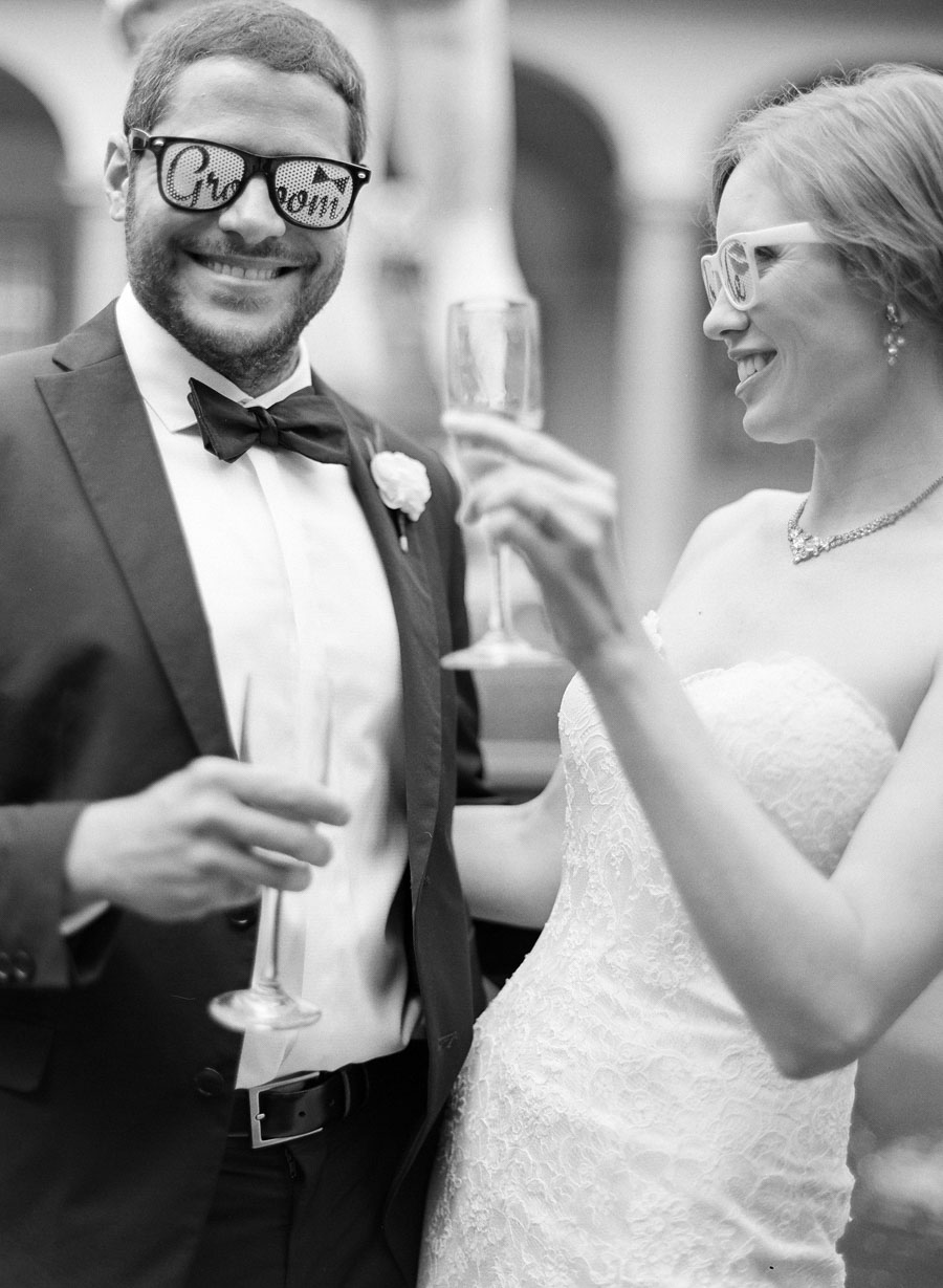 bride and groom toasting with playful sunglasses 