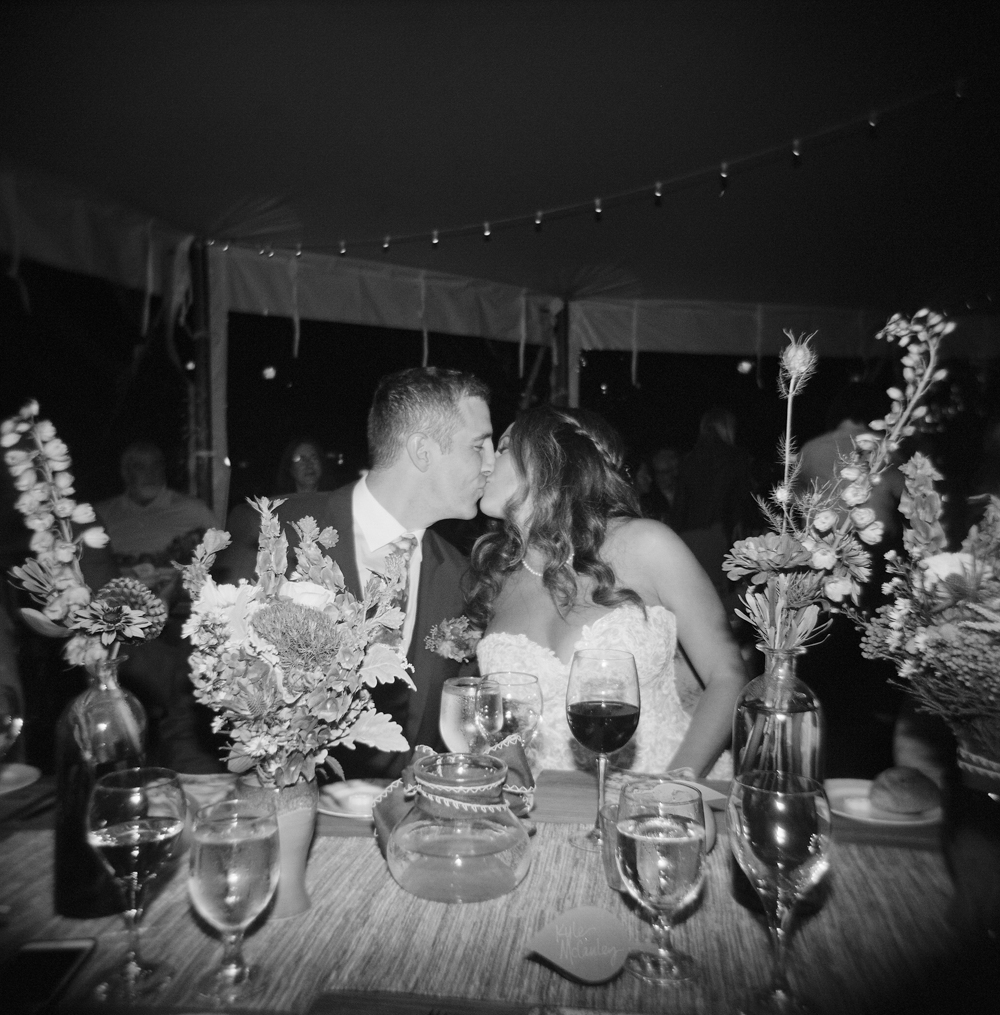door county weddings bride and groom kissing at a kings table
