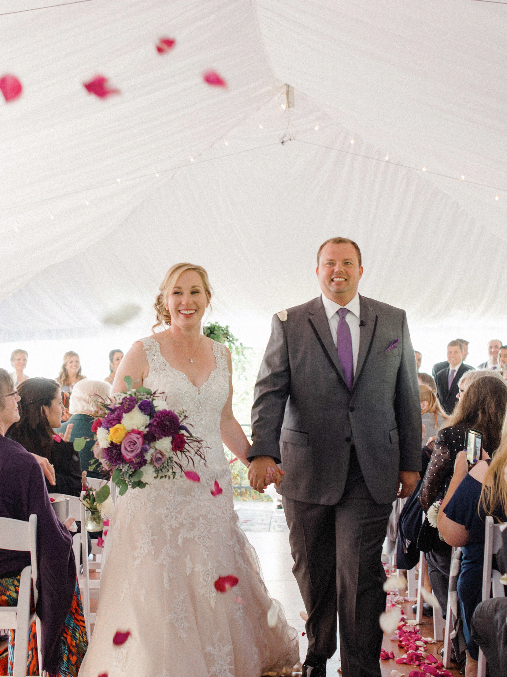 bride and groom recess down the aisle at door county tent wedding