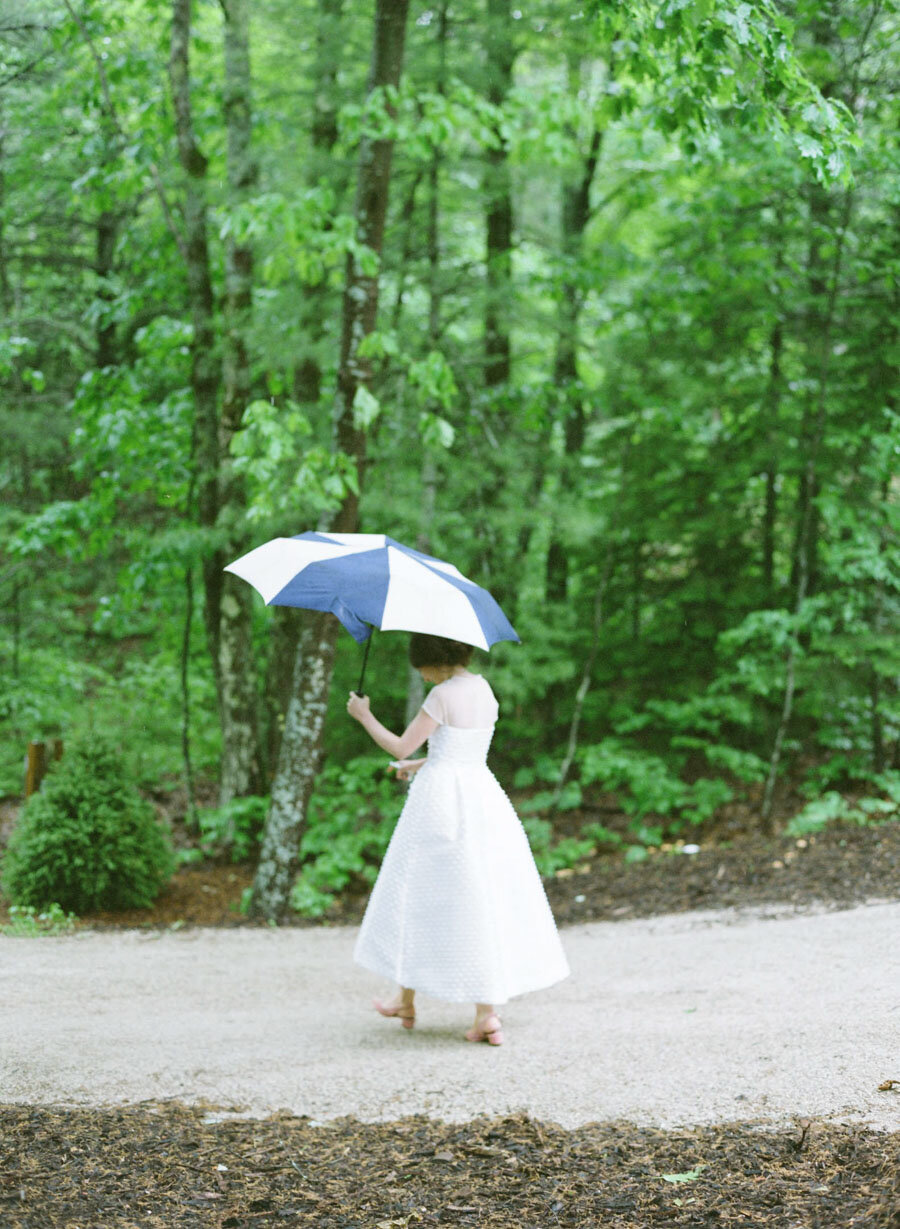 Door County Bride walking with an umbrella in the rain