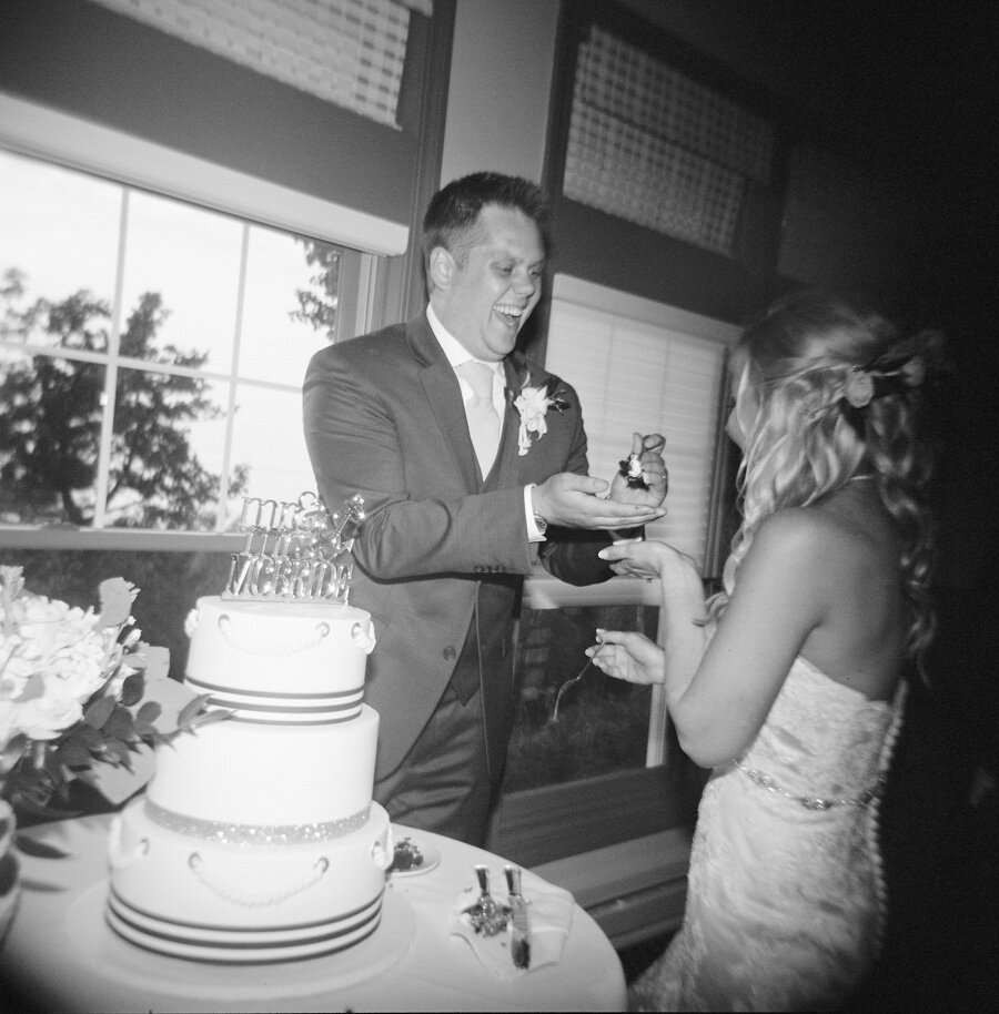 Bride and Groom cut the cake photographed with film on a Holga camera