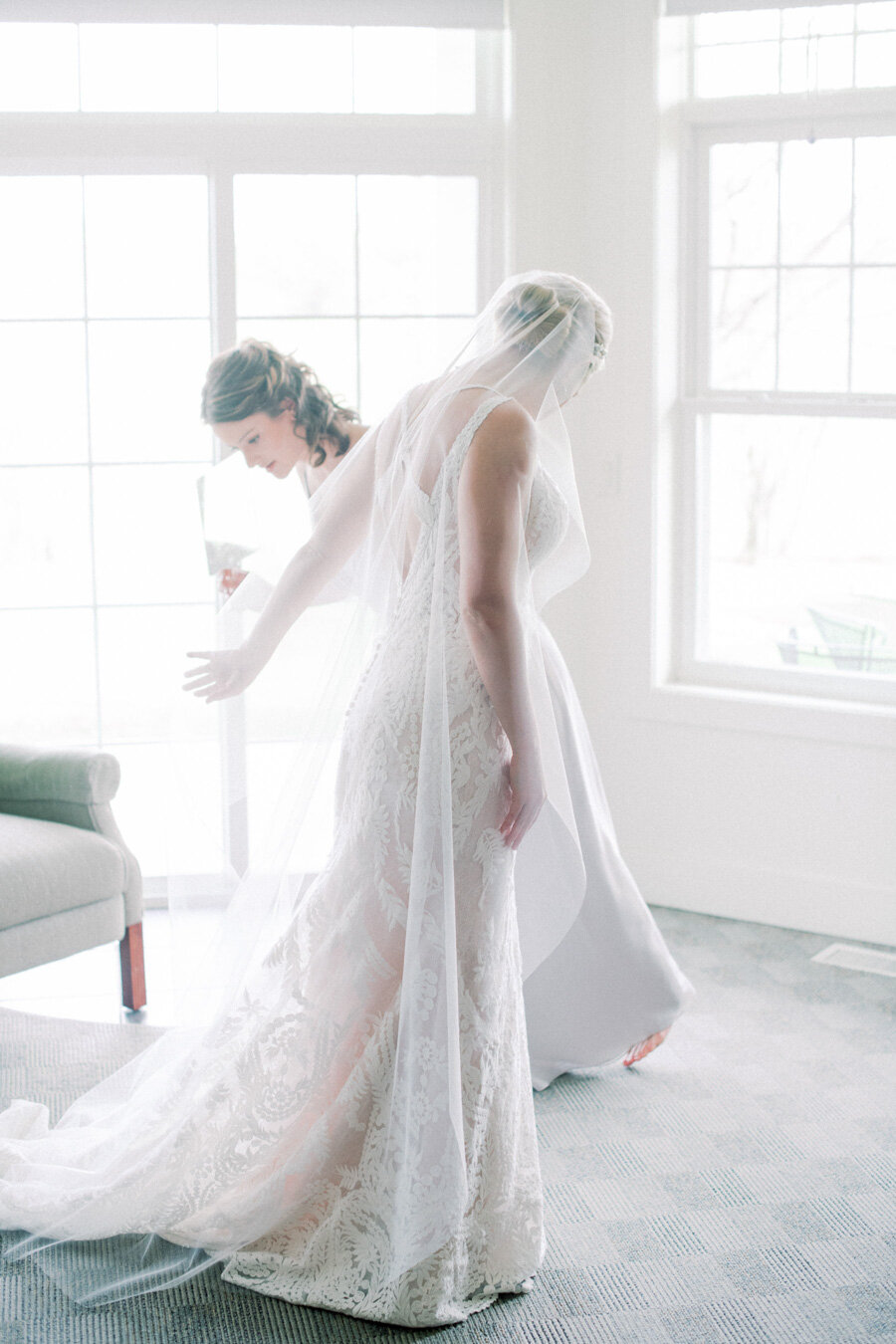 bride puts on dress before her door county wedding