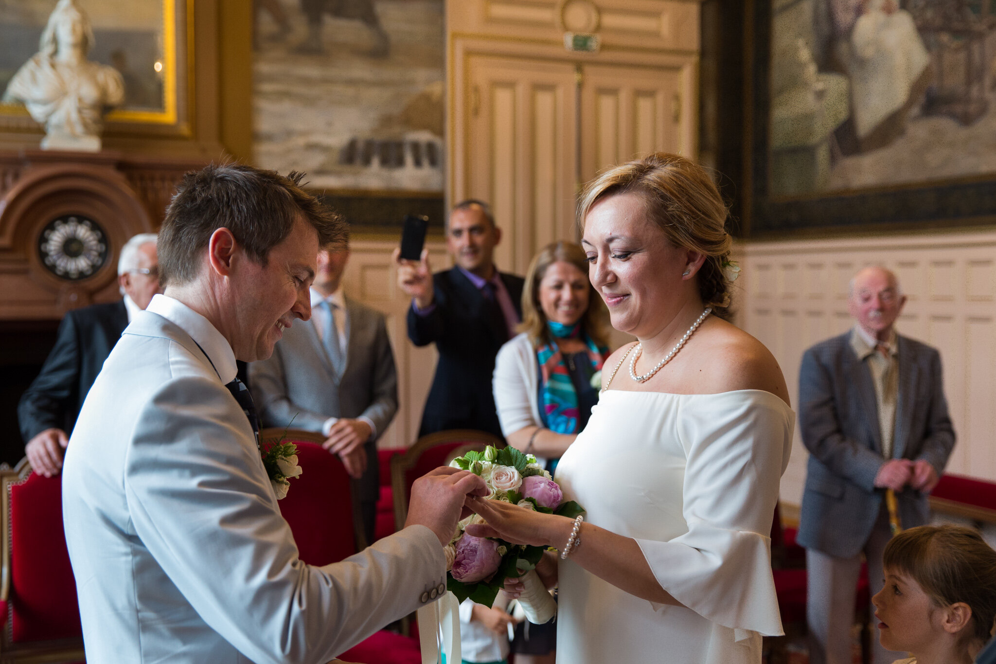 groom-puts-ring-on-finger-in-mairie-town-hall 