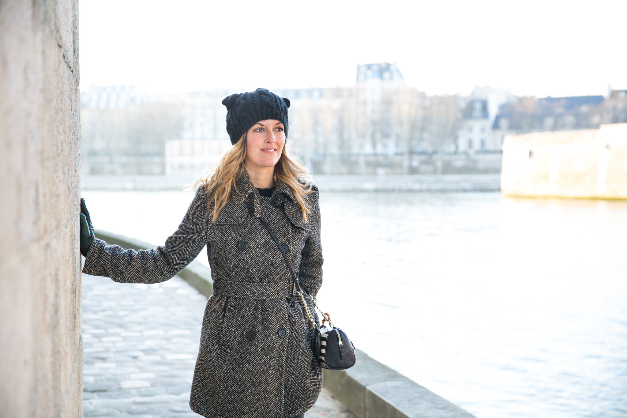  english-speaker-leans-on-notre-dame-quais-wall-overlooking-water 