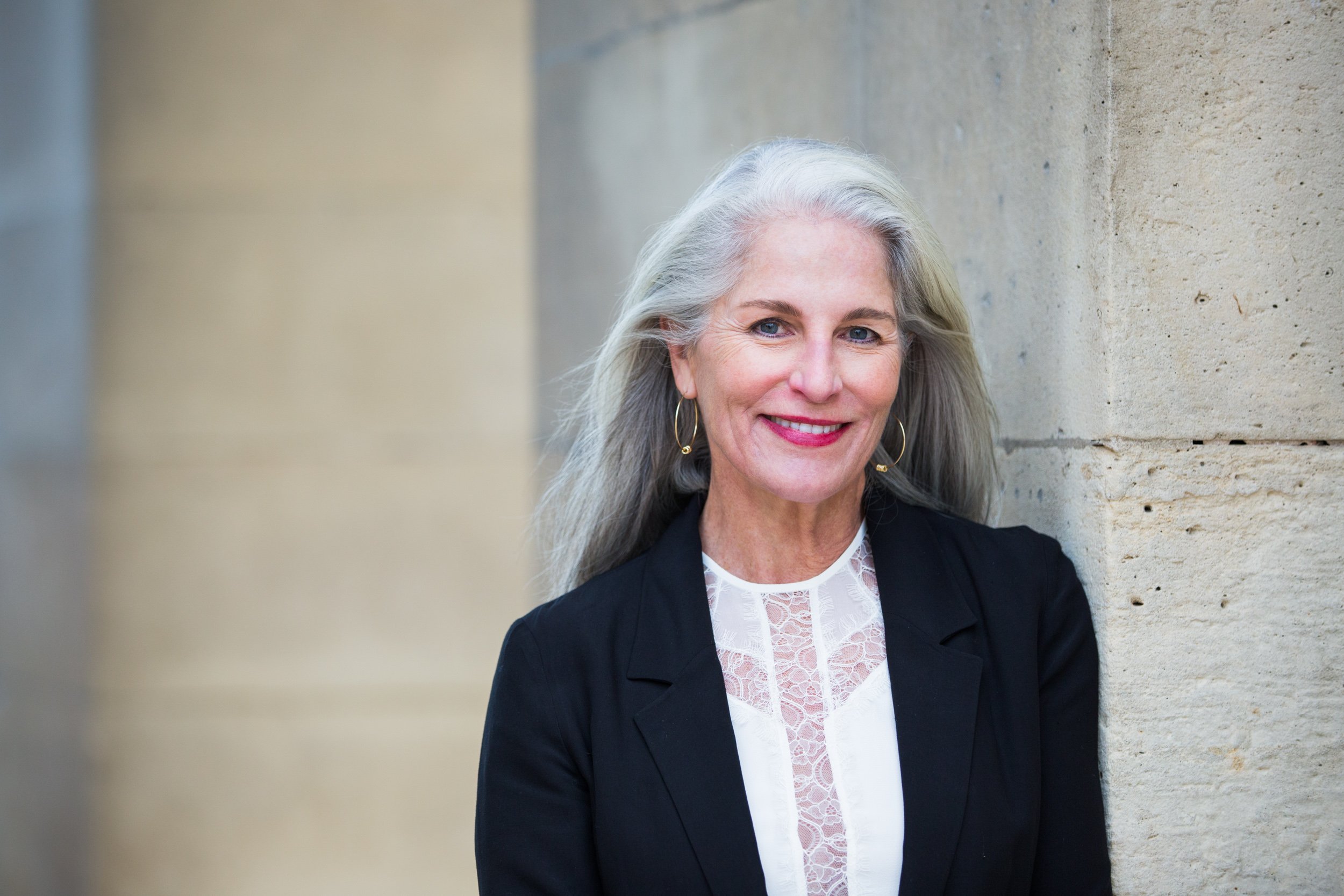  attractive-author-leans-against-archway-wall-near-louvre 