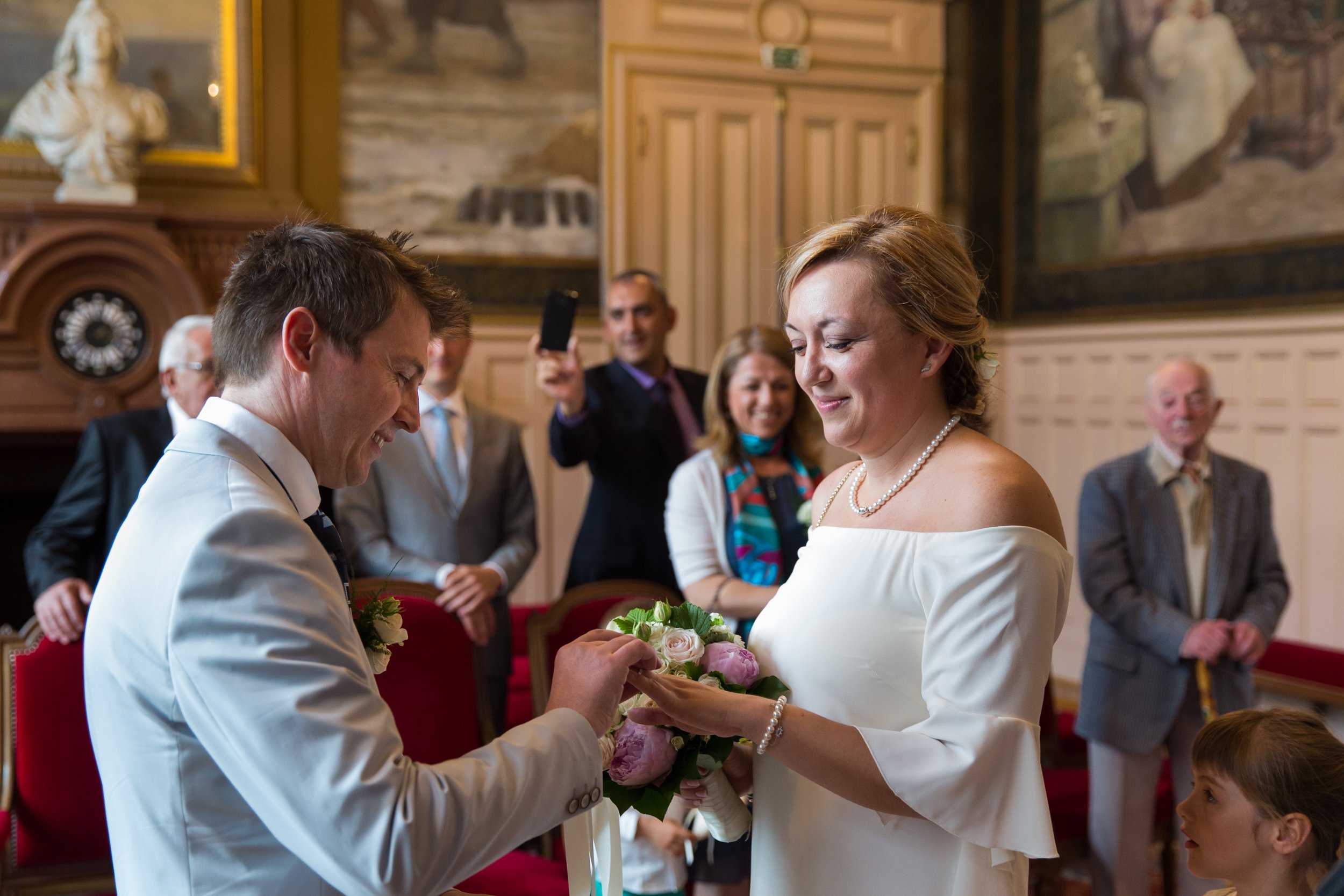  groom-puts-ring-on-finger-in-mairie-town-hall 