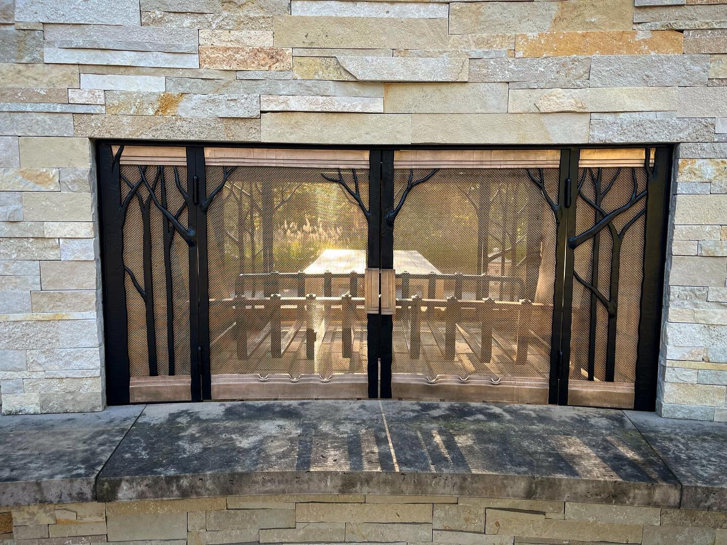 Completed fire screen project. Two 60&rdquo; wide curved fire screens. Forged bronze and steel. Stationary side panels with double doors. We previously made the 42&rdquo; wide fire basket in the fireplace. A really lovely project for an amazing outdo