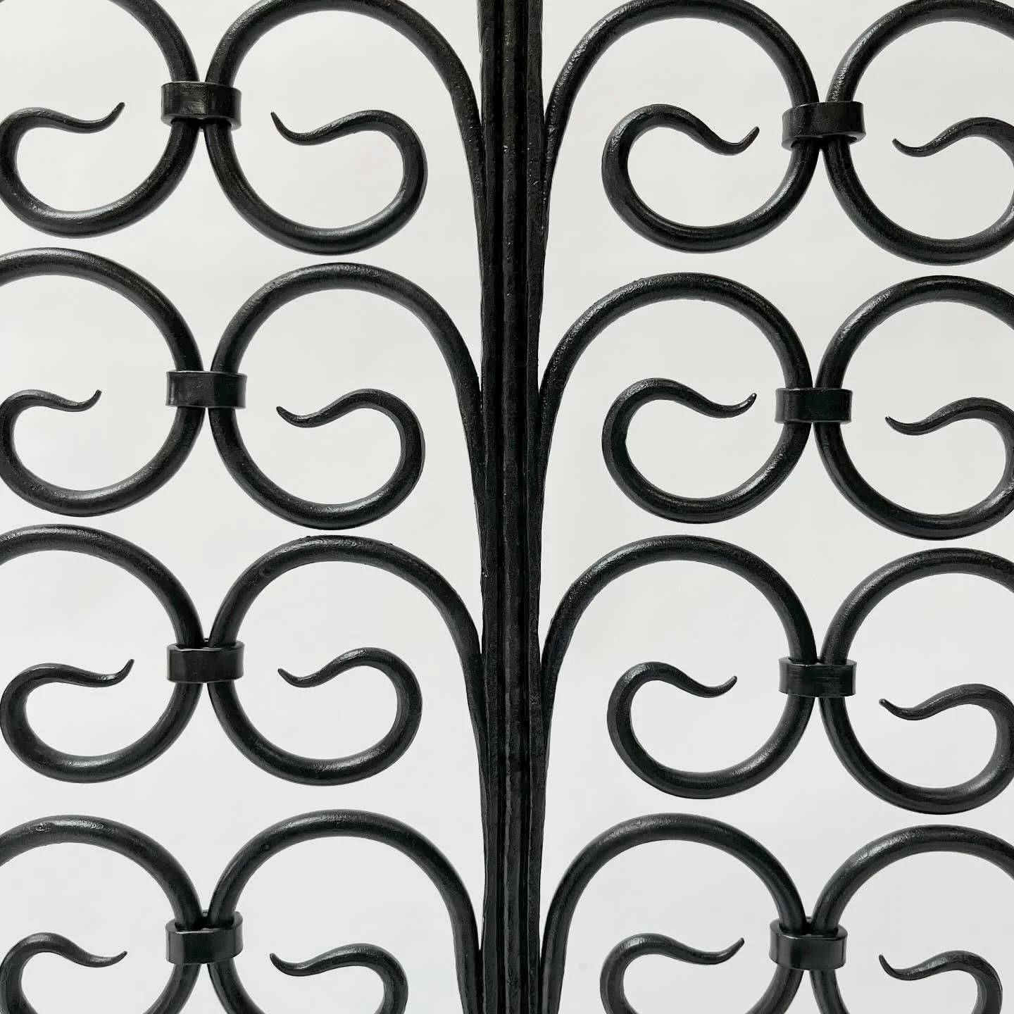 Presenting our latest effort&mdash; a firescreen featuring a field of recumbent scrolls. Highlights include anthropomorphic feet, vertical bars that pierce and wrap the frame, collars that connect the scrolls, finials that punctuate the composition, 