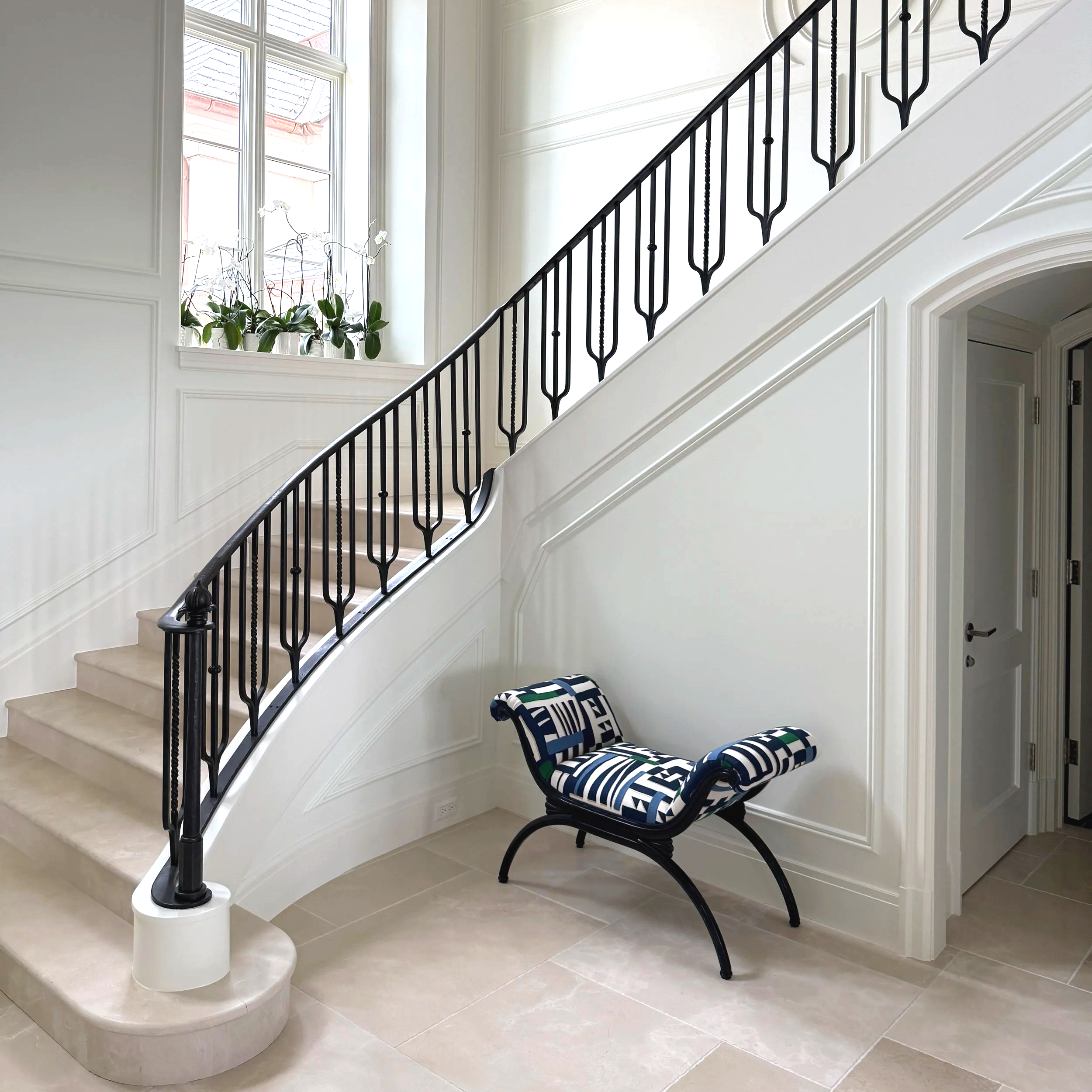 A railing made bySmith Shop  gracefully curves up past a landing.