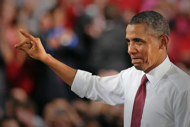 President Barack Obama gives the Wolfpack hand sign as a salute to the "Think and Do" mentality of NC State during his visit.
