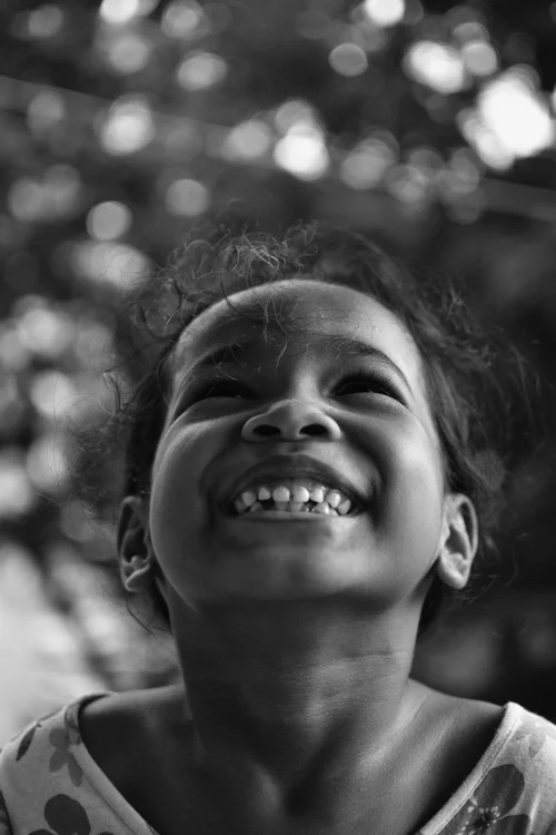 A smiling child looking upward.