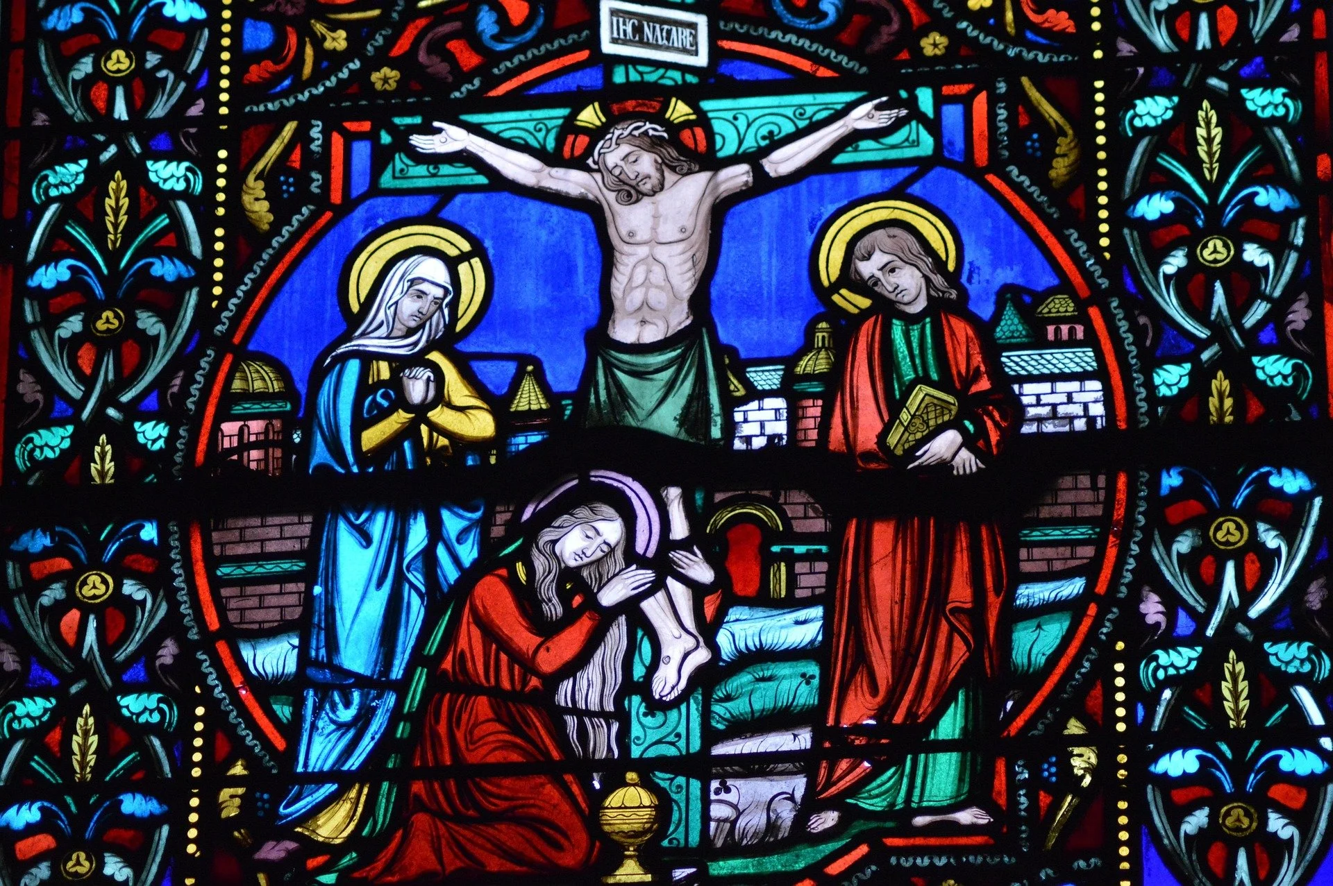 A stained glass image of Christ crucified