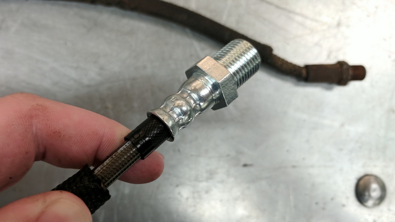 The outer wire loom housing pulled back to reveal the braided stainless hose within 