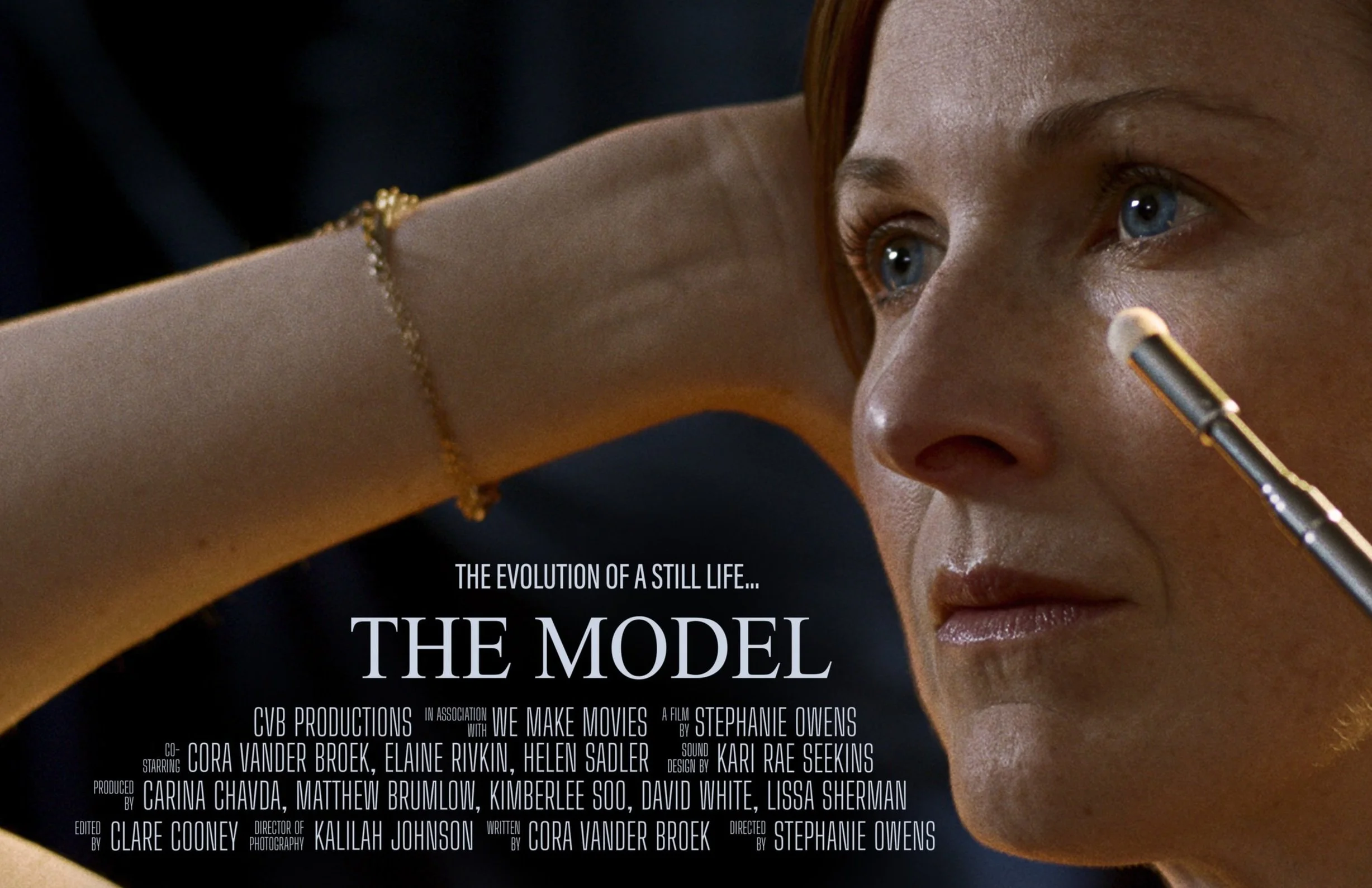 Close-up of a woman with blue eyes and red hair, looking intently to the right, with text overlay about a film titled 'The Model' and credits.