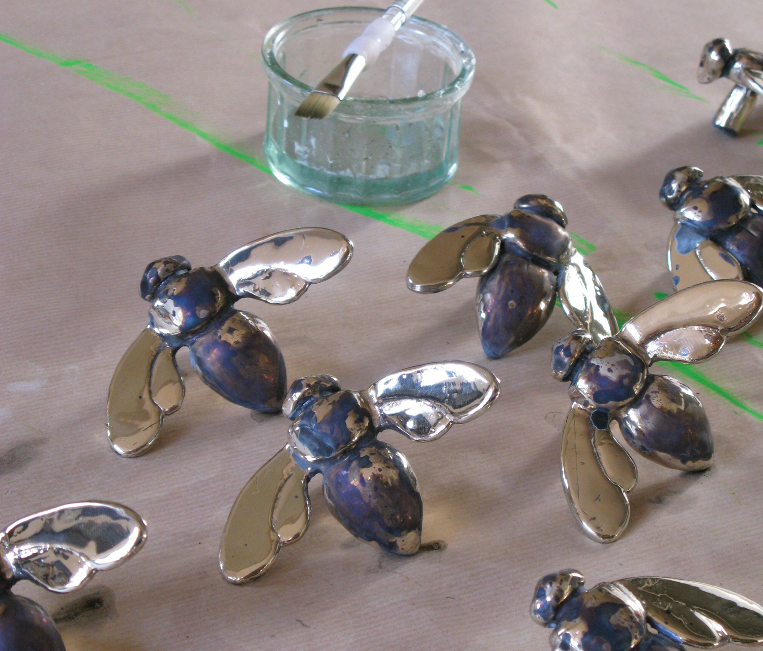 Individually painting the patina on the Bronze Bees