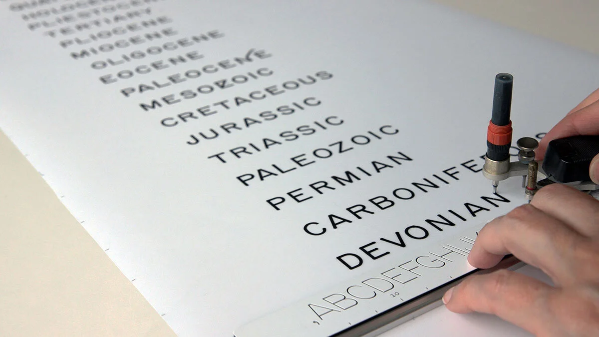  Video still from Epochs &amp; Eons, 2020 HD video, 40-minute loop  Throughout the forty-minute  Epoch &amp; Eons  video, words describing the geologic time-scale are carefully hand drafted in real time using an outmoded mechanical drafting tool.  Th