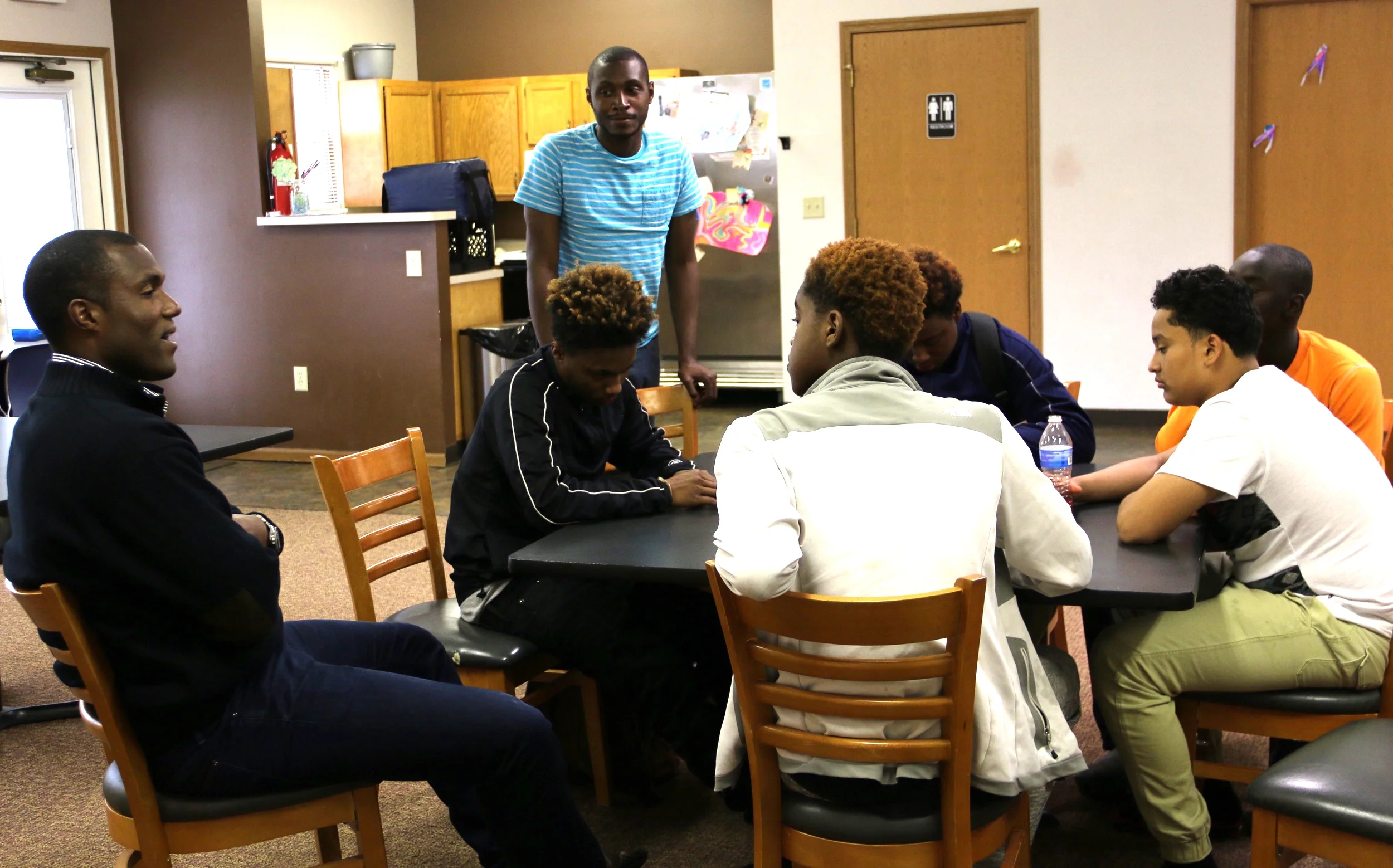 Mark, center, looks on at Marsh Run Apartments while special guest George Foreman III, left, speaks to teens.