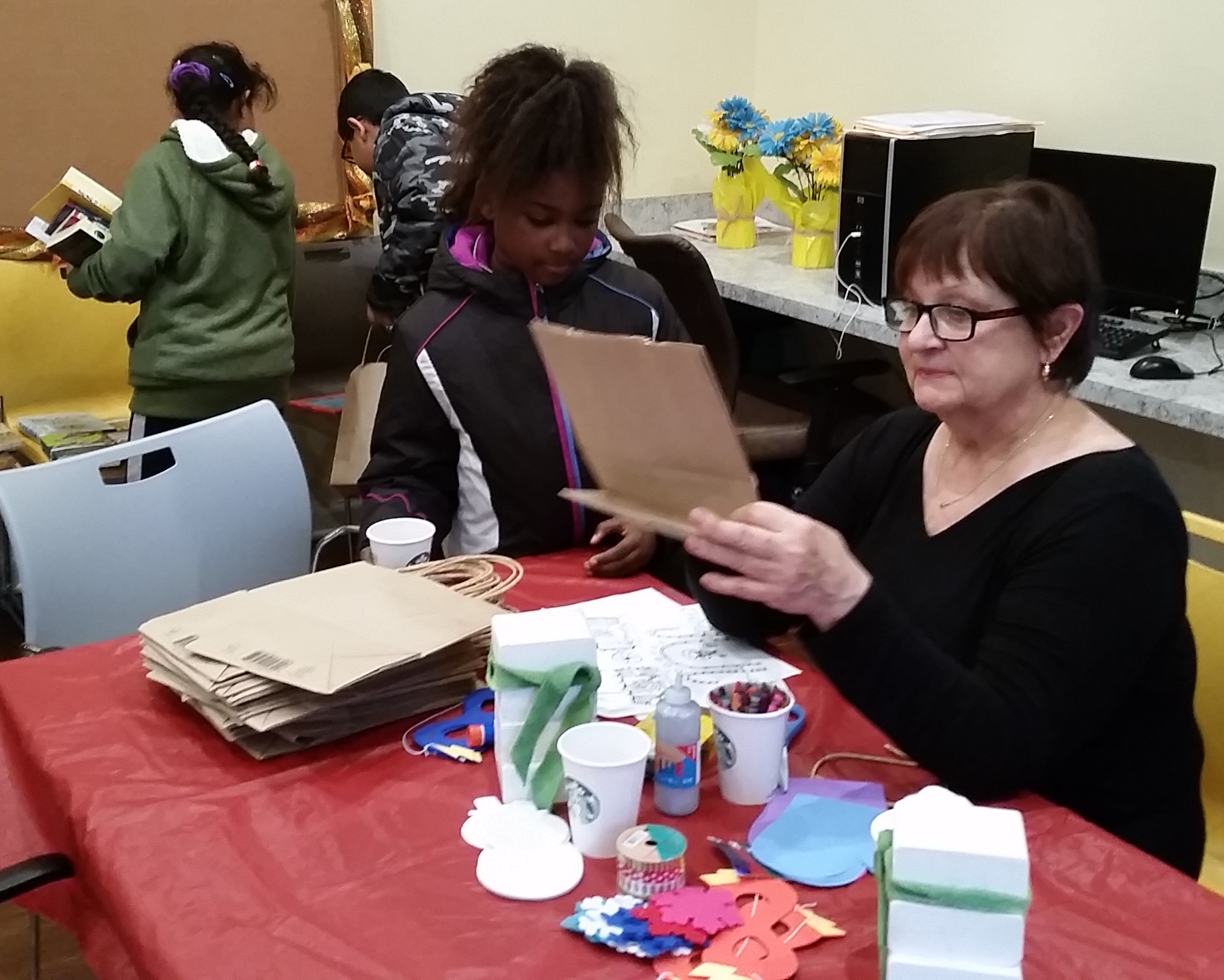 Deb Coffelt helps young Trabue Crossing resident make a ginger bread house