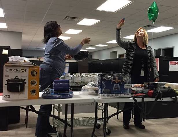 Staff Accountant Sherri Clark draws a winning ticket. Assisting her is Laverne Price, Senior Director of Resource Development.