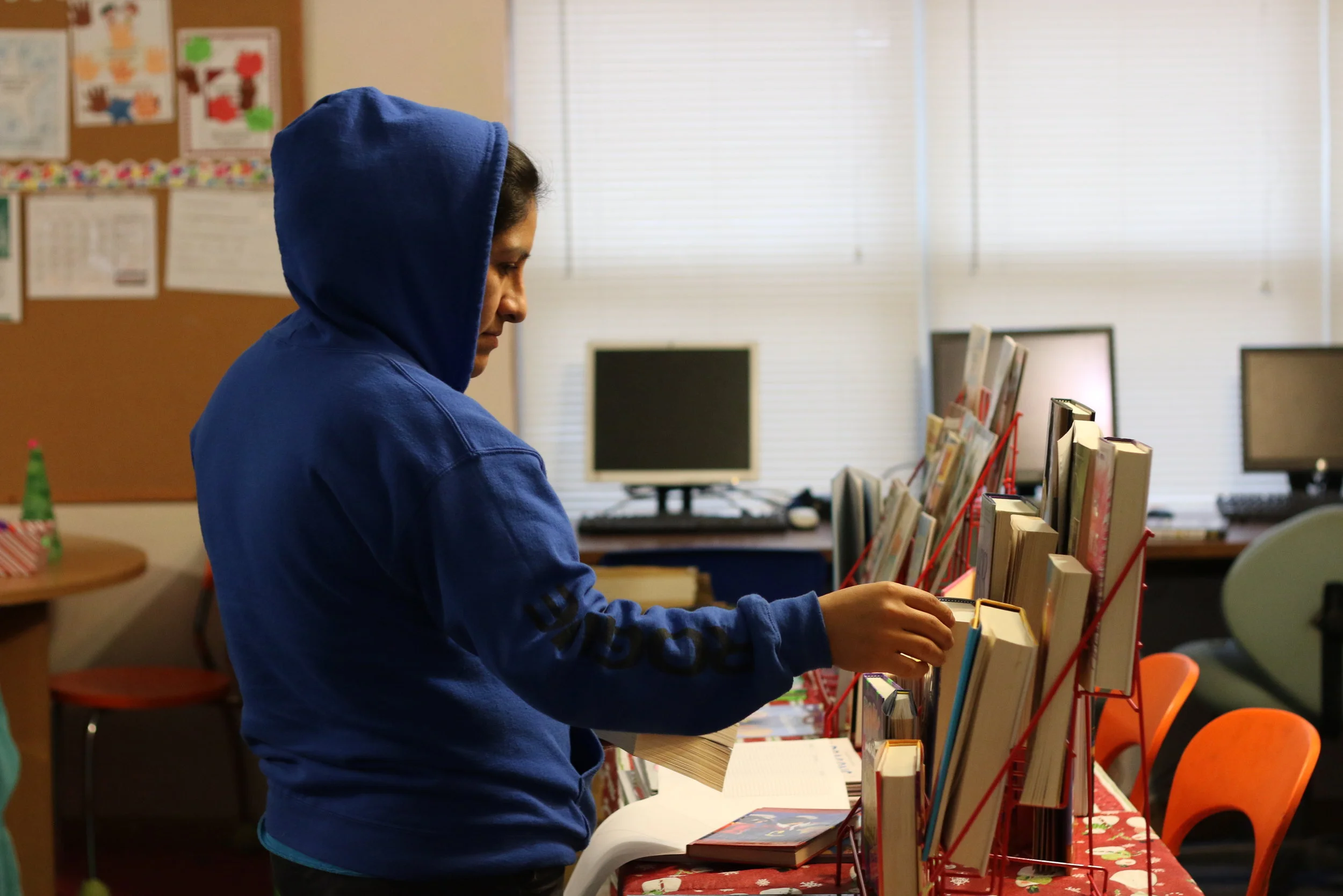 Emerald Glen's Lourdes Cruz checks out books for her three girls