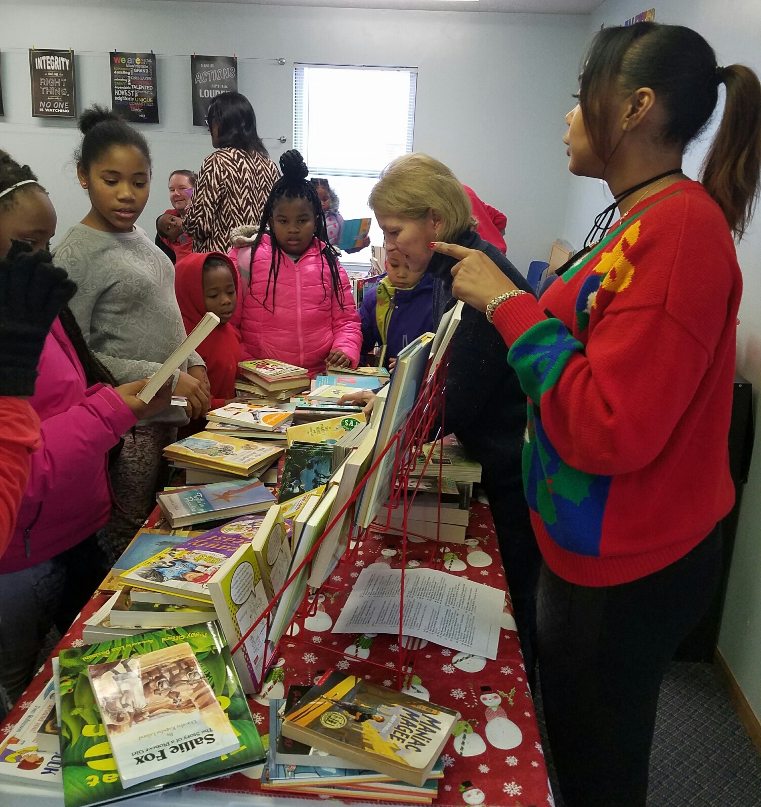Homeport Board Chair Chris Hune, second from right, helps children select books at Georges Creek book fair event.