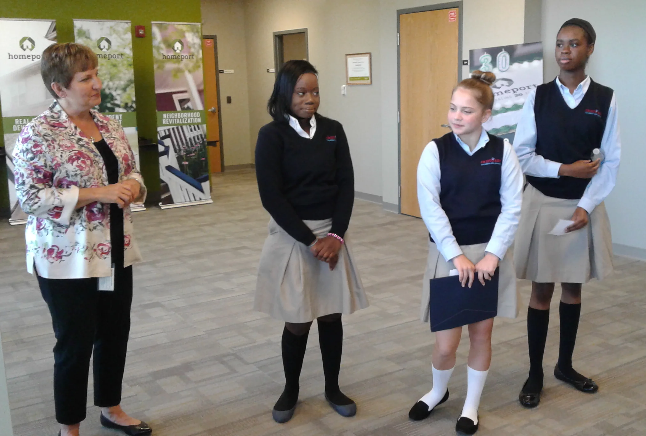 Homeport on Aug. 24 welcomed for the first time work-study program participants from Cristo Rey High School in Columbus. Pictured left to right in the photo above is Chief Administrative Officer Beth Ware and students Hadja Diouf, Myra Wood and Brianna Bollers. After orientation, the students had lunch. In the second photo, Howard Fairley, a Cristo Rey junior, center, hears, between bites of lunch, from Asset Management's Josh Martin. The students begin working at Homeport after Labor Day.