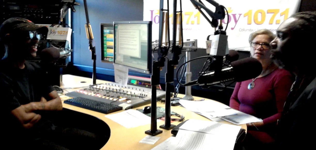 Radio One community affairs host Yaves Ellis, left, banters with Homeport's Layden Hale, right, and Isabel Giles.