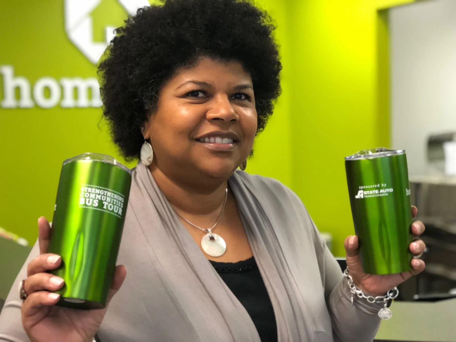 State Auto's Stephanie Meredith lifts drink cups that tour participants will receive.