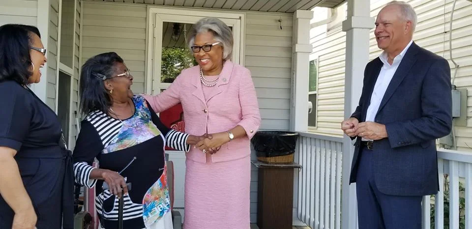Joyce Mayne, second from left, accepts a congratulatory handshake on her front porch from U.S. Rep. Joyce Beatty. On right is Homeport President & CEO Bruce Luecke. On left is Homeport Lease Option Program Manager Brenda Moncrief.