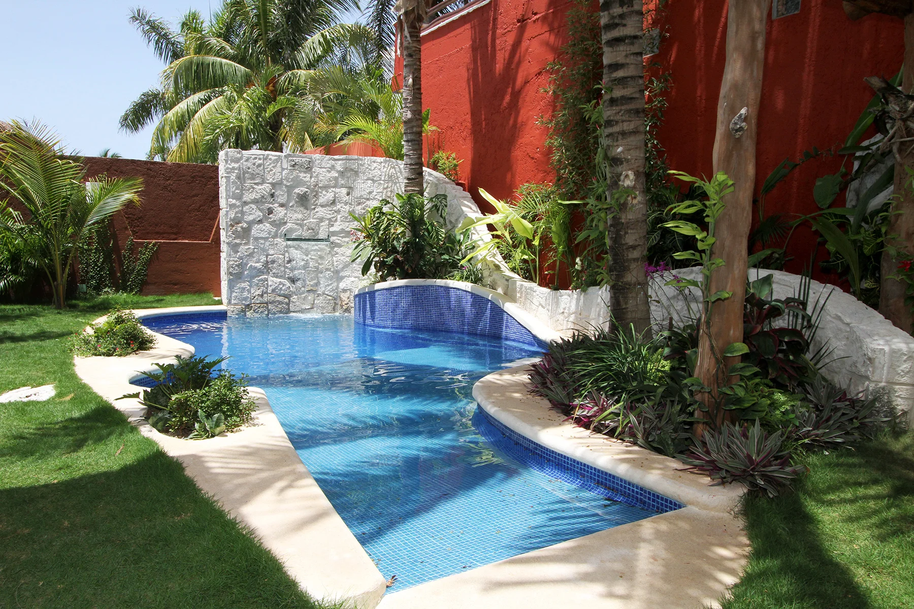 The small pool is designed to accommodate multiple family activities. The entrance introduces a shallow slope for easy access via wheelchair. A shallow area allows for sunbathing or an opportunity for the family dogs to cool themselves off. A backre