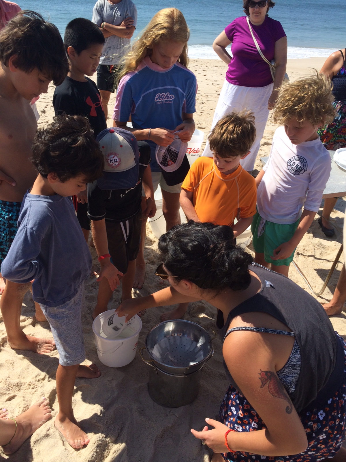  Shelly showing the kid’s how to strain salt water properly.  Photo: Molly Adams,&nbsp;SoFo.org  