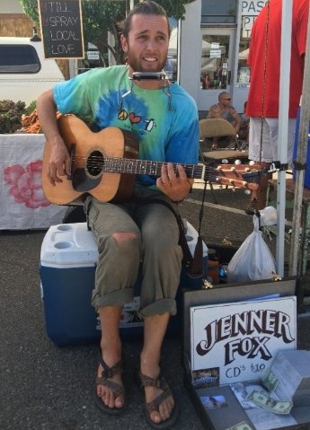 Pictured above is an honest American, chasing the dream, almost making enough at a Saturday market to buy new pair of pants. But more importantly he was able to trade a song for a really big homegrown tomato.