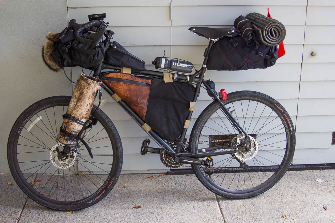 The tripod and platypus 2-liter water bladder sit on either side of my fork in cages with straps.