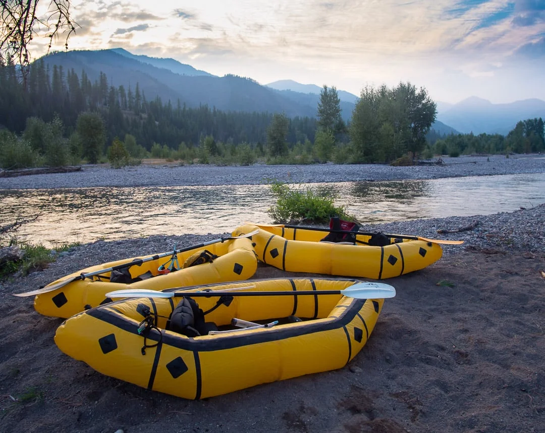 Packrafts and paddles wait next to the waters of the Flathead River - Photo: Colin Arisman