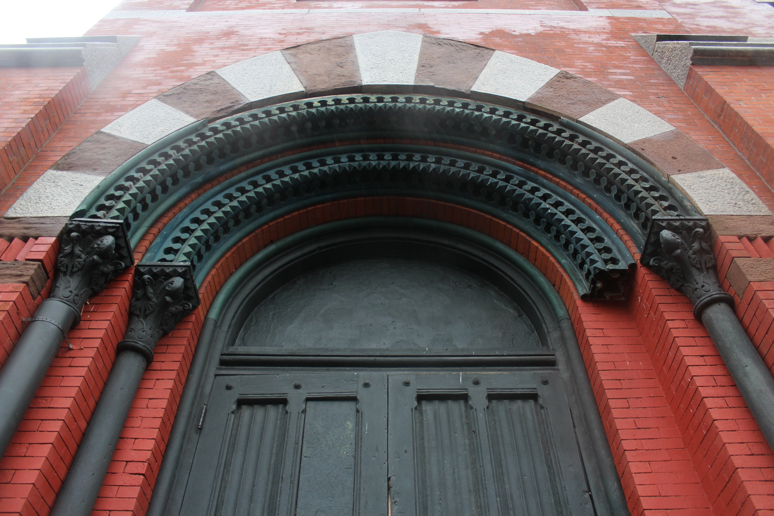  One of two elaborate entrances with original wood panel doors, columns and stone trim 