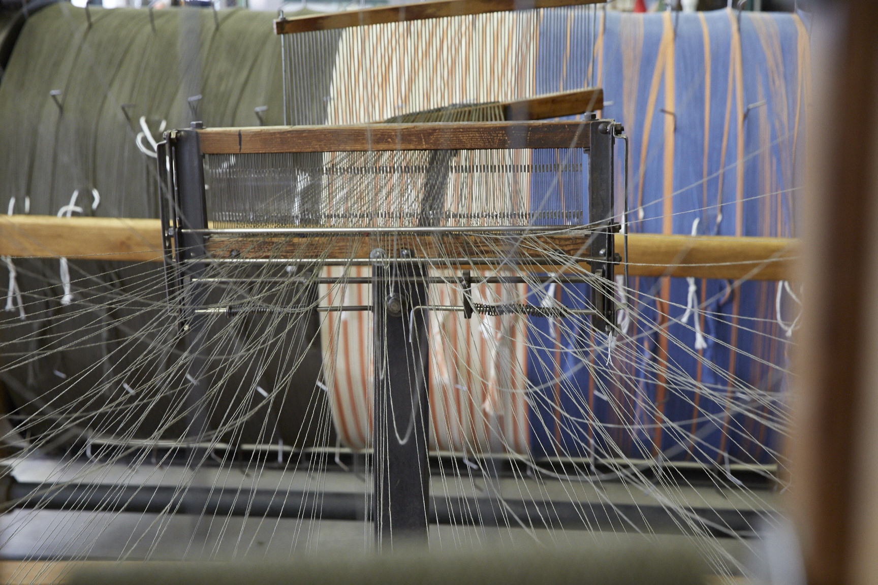 Photo By Jennifer Marx, 2016. 8/2 cotton yarn comes off the cones from a giant spool rack and is wound directly onto a an industrial sized warp drum, which then gets wound onto the back of the Somet loom at The Weaving Mill in Chicago, IL.