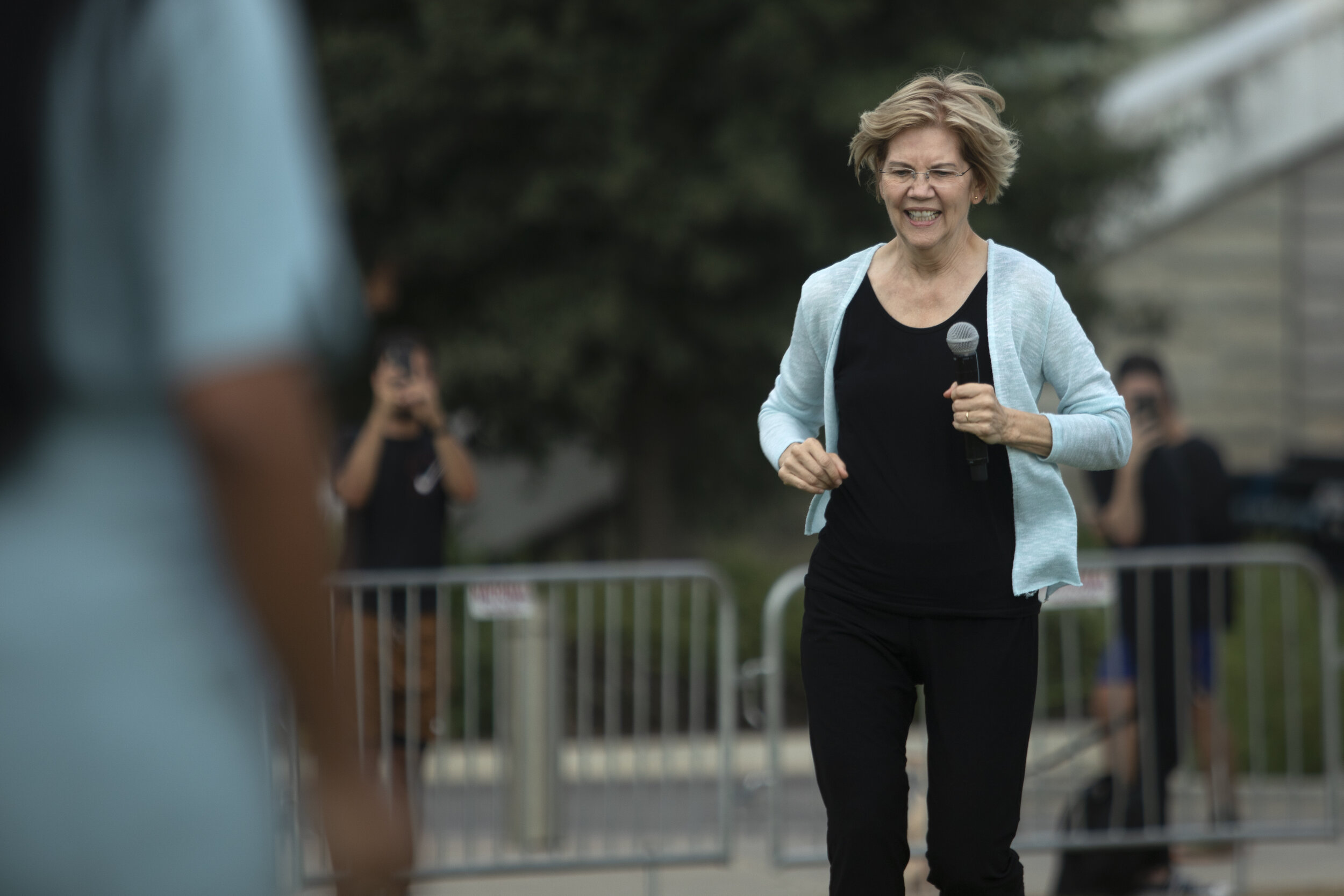 AUSTIN, TX. Elizabeth Warren runs to take the stage during a rally at Auditorium Shores. 