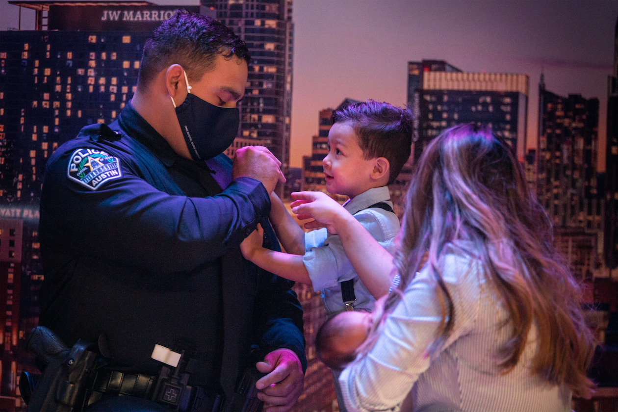  AUSTIN, TX. Oct. 23, 2020. Officer Thomas Bores (left) helps his son and wife perform his pinning during the graduation ceremony for the 143rd cadet class. The graduation took place at the Great Hills Baptist Church, and will be the last graduation 