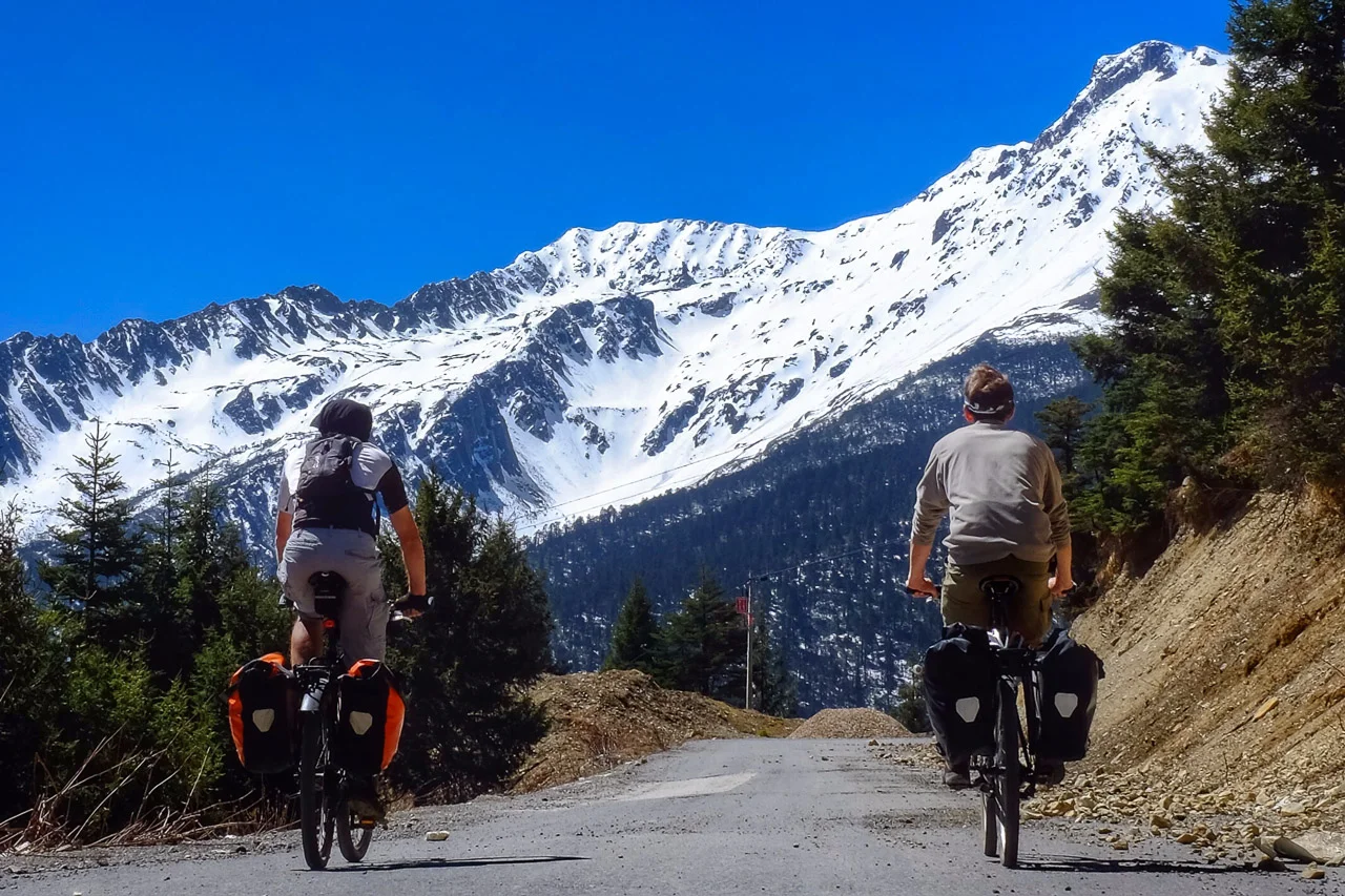 Pedaling the old route G214 towards the Baimang Mountain pass.