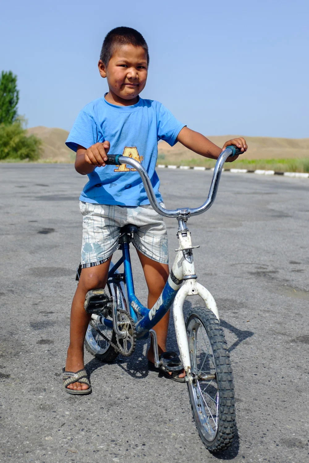 A boy and his bicycle (note the flat rear tire)
