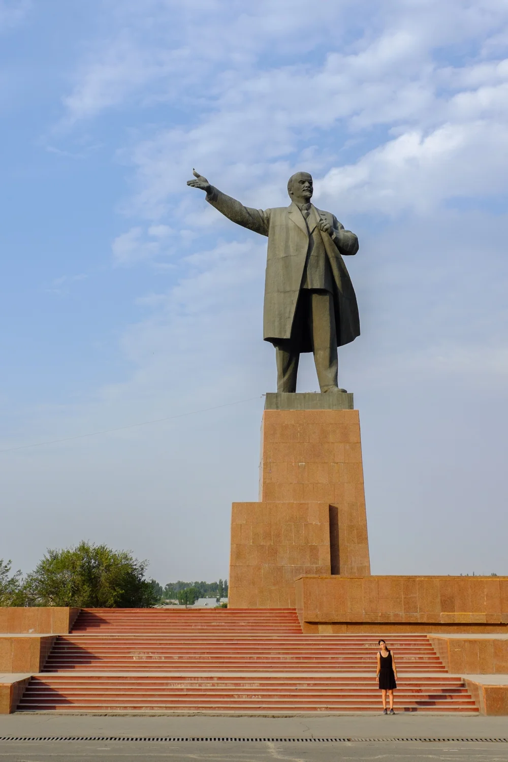 Erica standing beneath a giant statue of Lenin in Osh