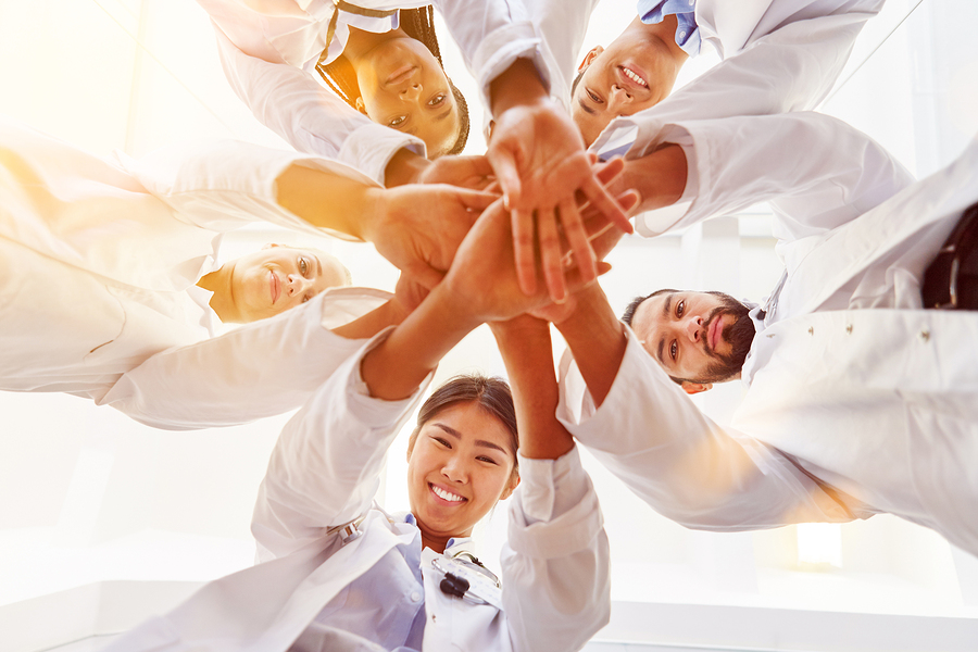 bigstock-Many-happy-doctors-stack-hands-172770227.jpg