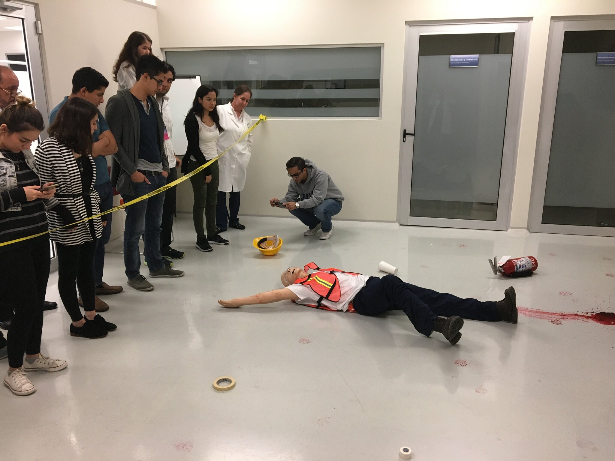 Image 2: Students analyze the crime scene using a mannequin.