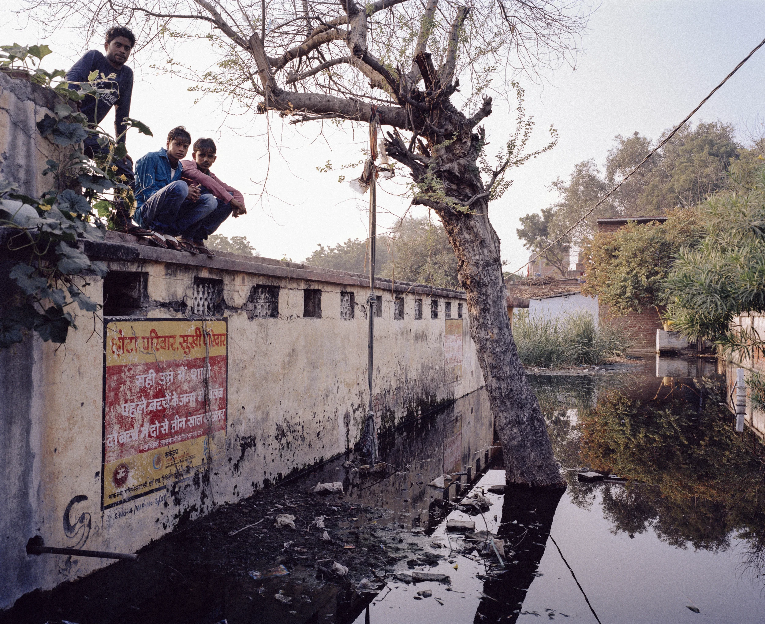 Stagnant water, near Anshu Jha’s house, Rajapurwa slum, Kanpur, India, 2014. itting in the middle of the pool is a broken water pump; garbage floats on the surface and mosquitos hover. In the rainy season, levels rise and the water intrudes on Anshu’s house. During this time of year water and sanitation related sickness is rife. Credit: WaterAid/ Mustafah Abdulaziz