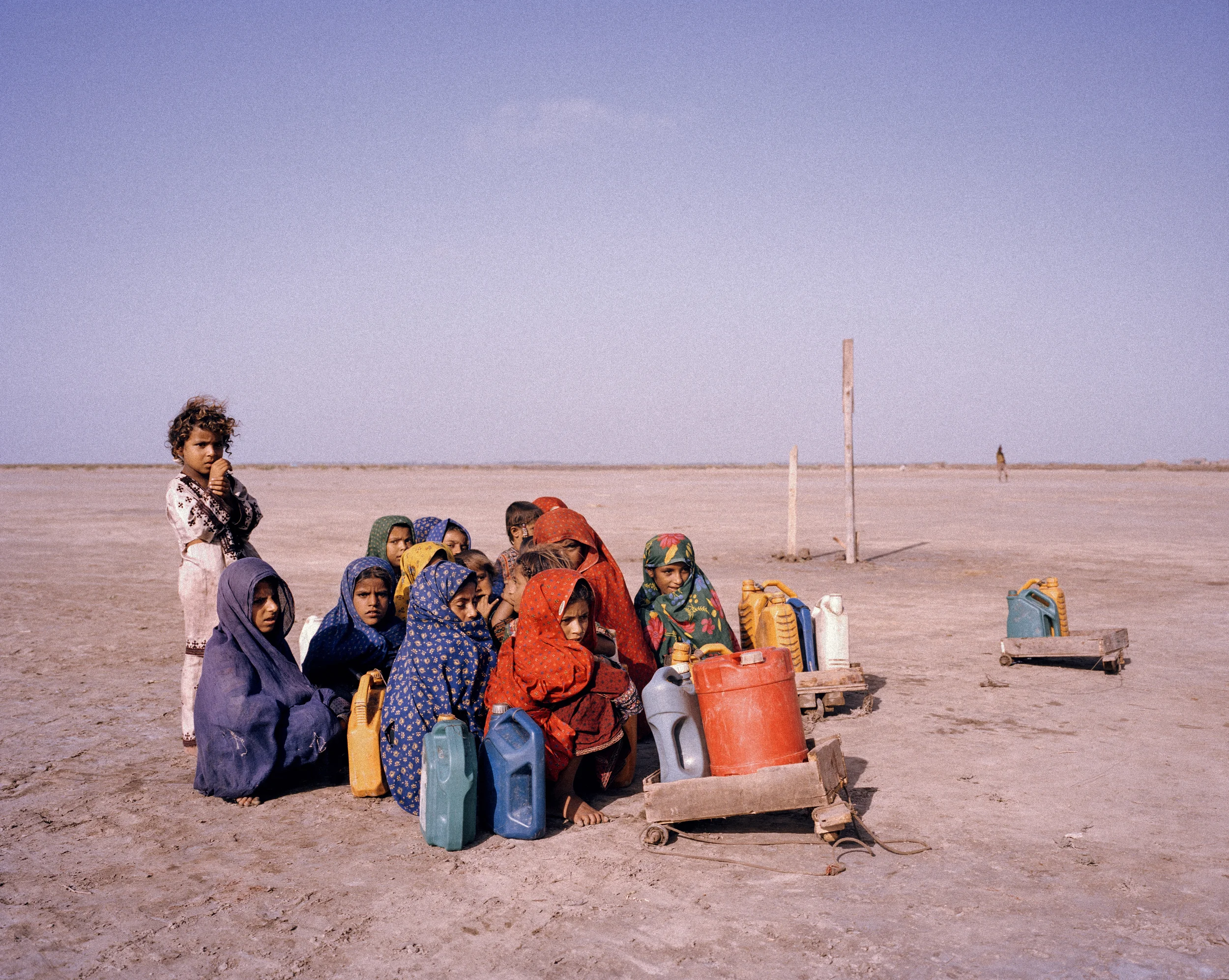 Children journey to collect water, Sindh Province, Pakistan, 2013. Children pause during their journey to collect water, huddling together against the wind in southern Sindh, where floods gripped the country in 2010 and 2011. Agriculture in the region was devastated. Credit: WaterAid/ Mustafah Abdulaziz