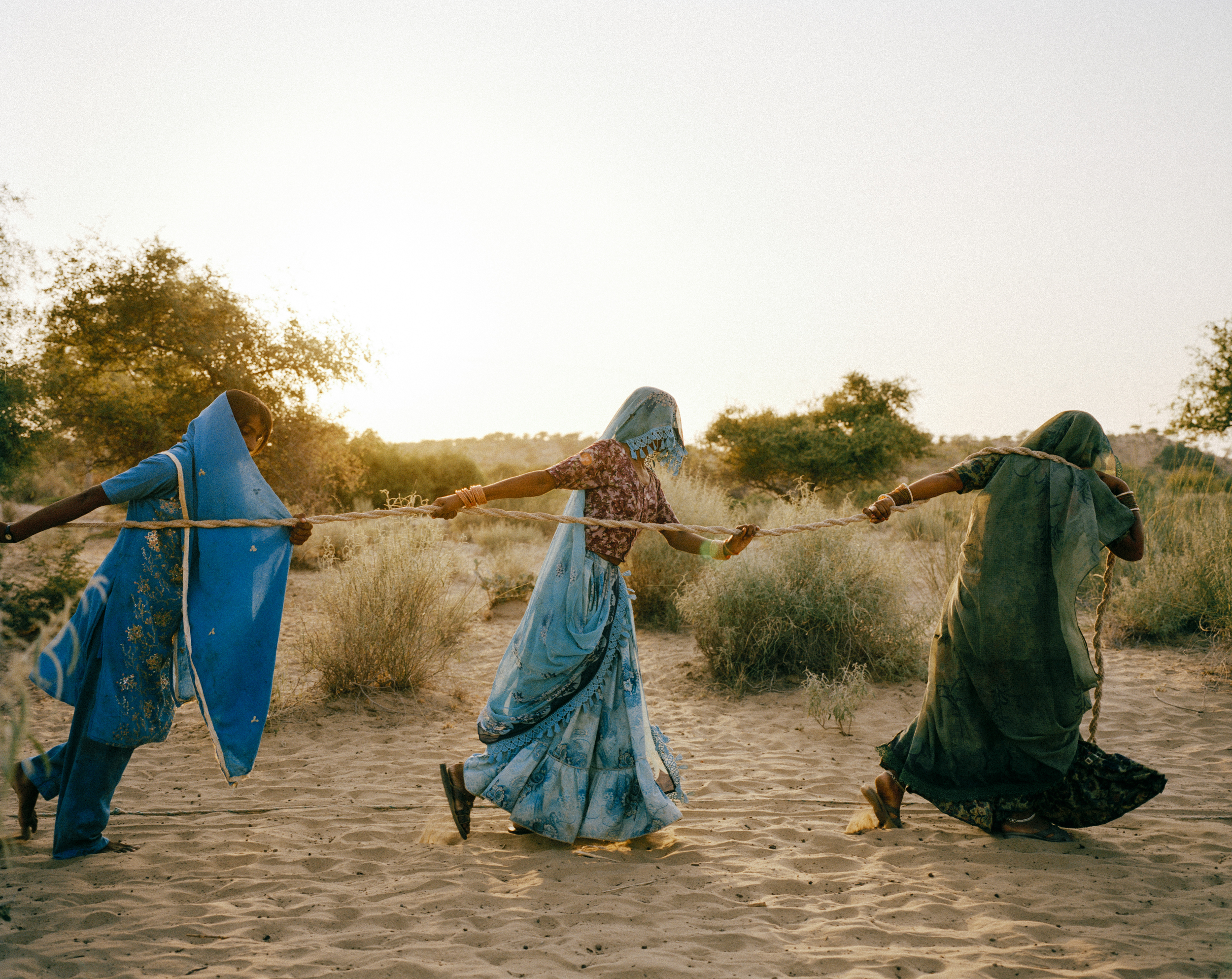 Women pull water from a well, Tharpakar, Pakistan, 2013. In the Thar desert, temperatures hover at 48-50°C on summer days. With an extremely low water table and continuing drought, sometimes water must be hauled from a depth of 150-200 feet. “Women fall unconscious on their way to these dug wells,” said Marvi Bheel, 45, a resident of Bewatoo, Tharparkar. The unending pursuit for water is a heavy demand on women worldwide. From the water-scarce regions in southern Ethiopia to the desert wells of Pakistan, it is women who are primarily responsible for gathering water. Credit: WaterAid/ Mustafah Abdulaziz