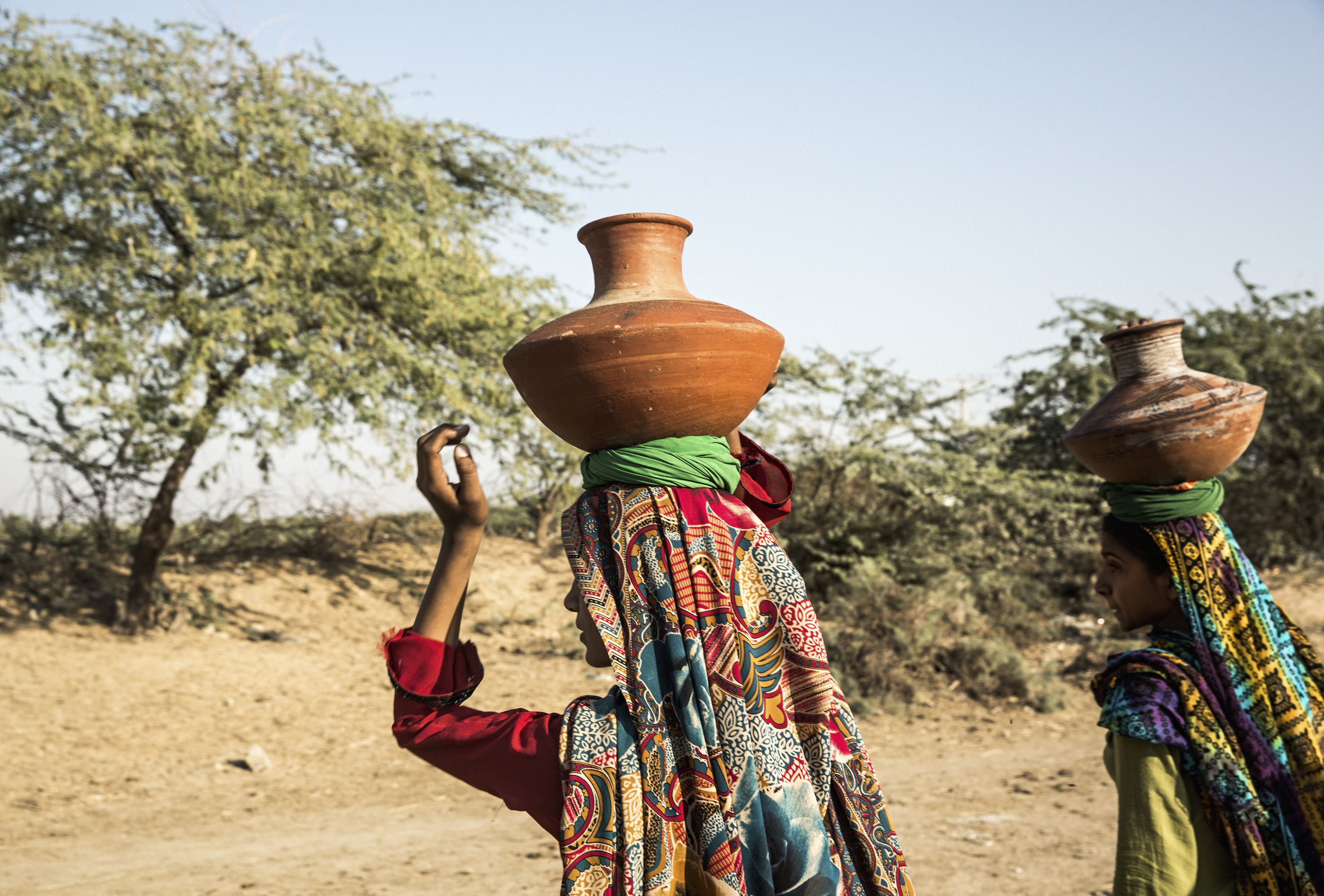Women collect water in traditional terracotta pots from the open canal in Noor Muhammad Thaheem. The canal transports drinking water from Keenjhar Lake to Karachi, however the local government will not allow the village residents to connect a pipe from the canal to their community, because they fear that the water supply to Karachi, which already suffers water shortages, will be reduced.