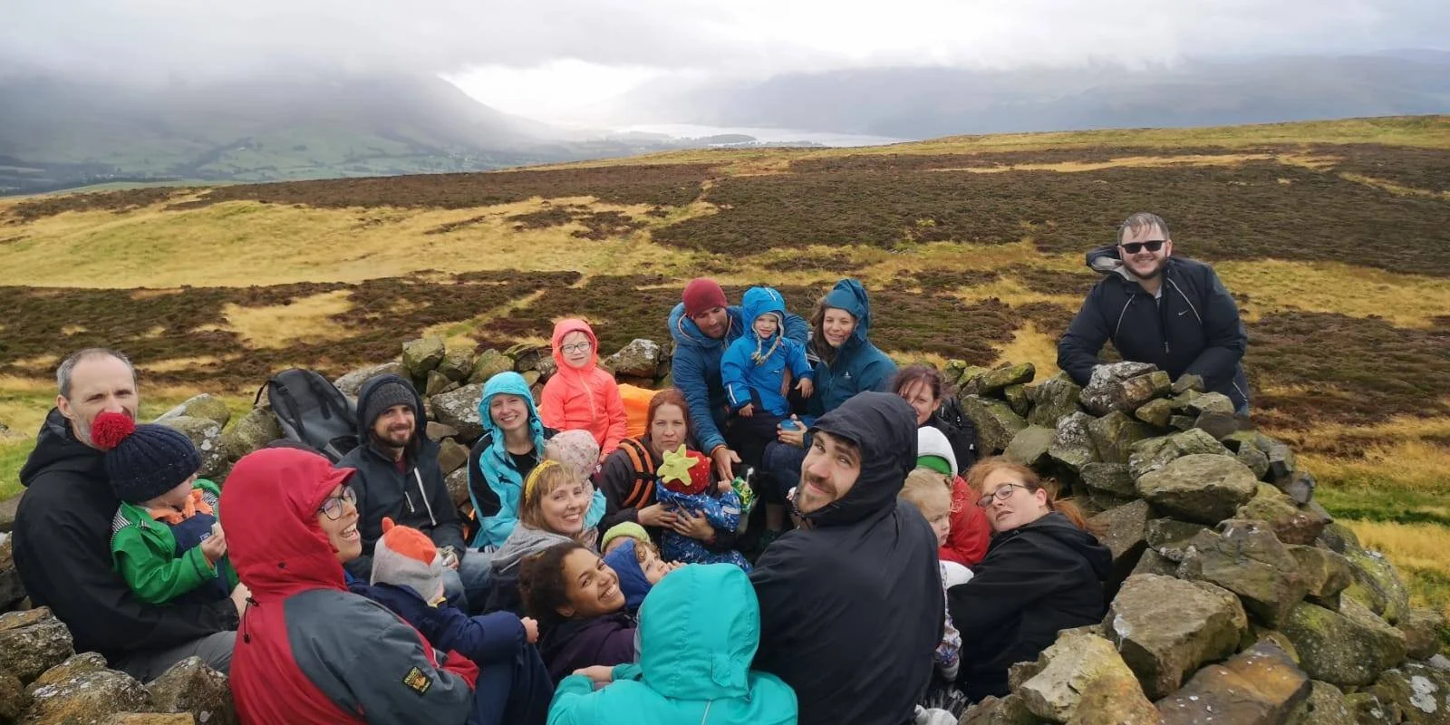 Group of adults and children on the top of Binsey Fell