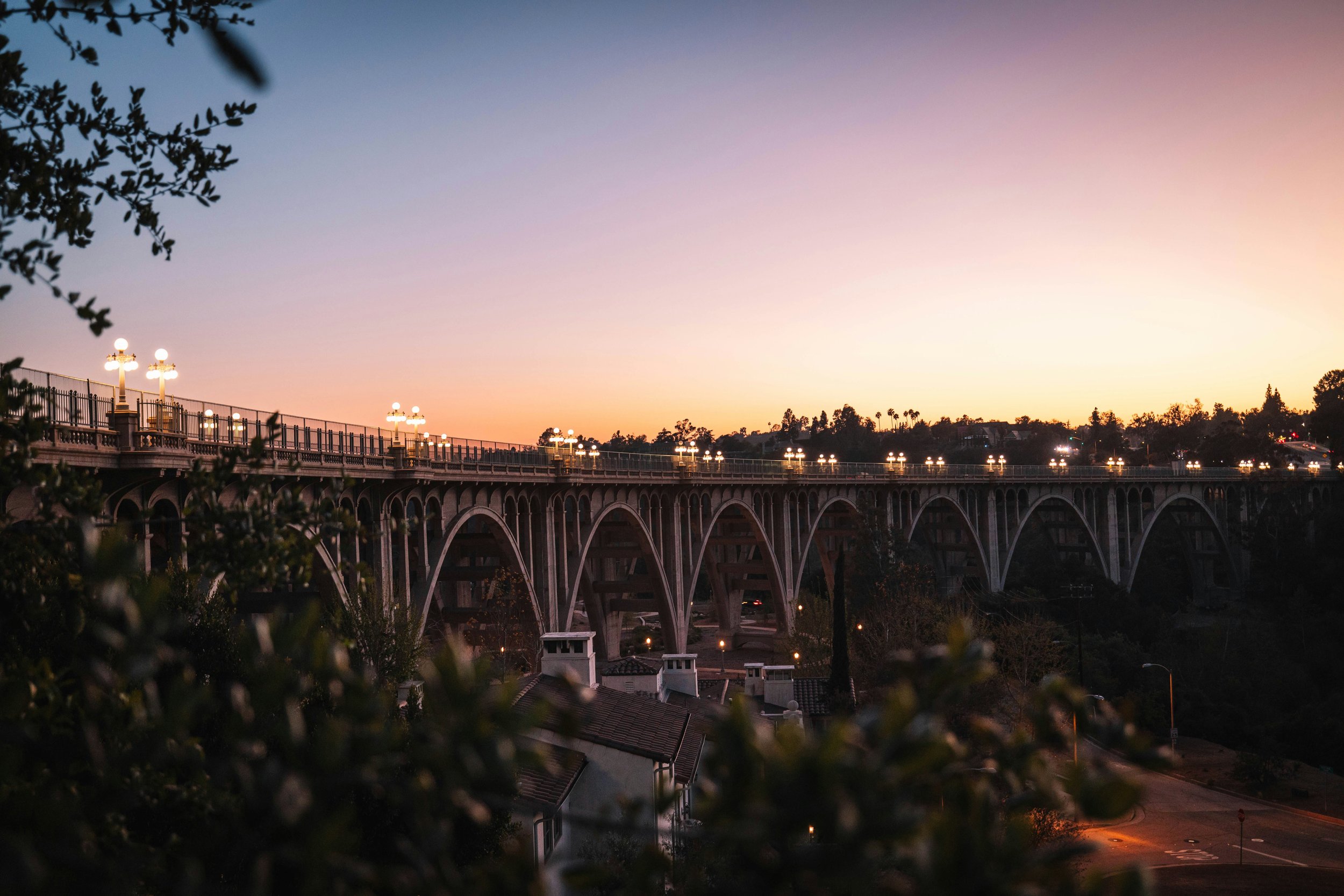 Colorado Street Bridge in Pasadena, California at sunset with historic arches and warm evening light