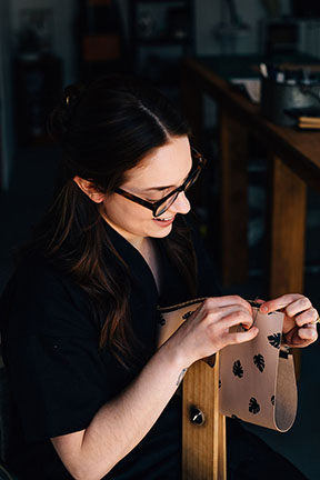 Megan hand stitching a Leather Monstera Print Zip Pouch in the Stitch &amp; Shutter Studio 